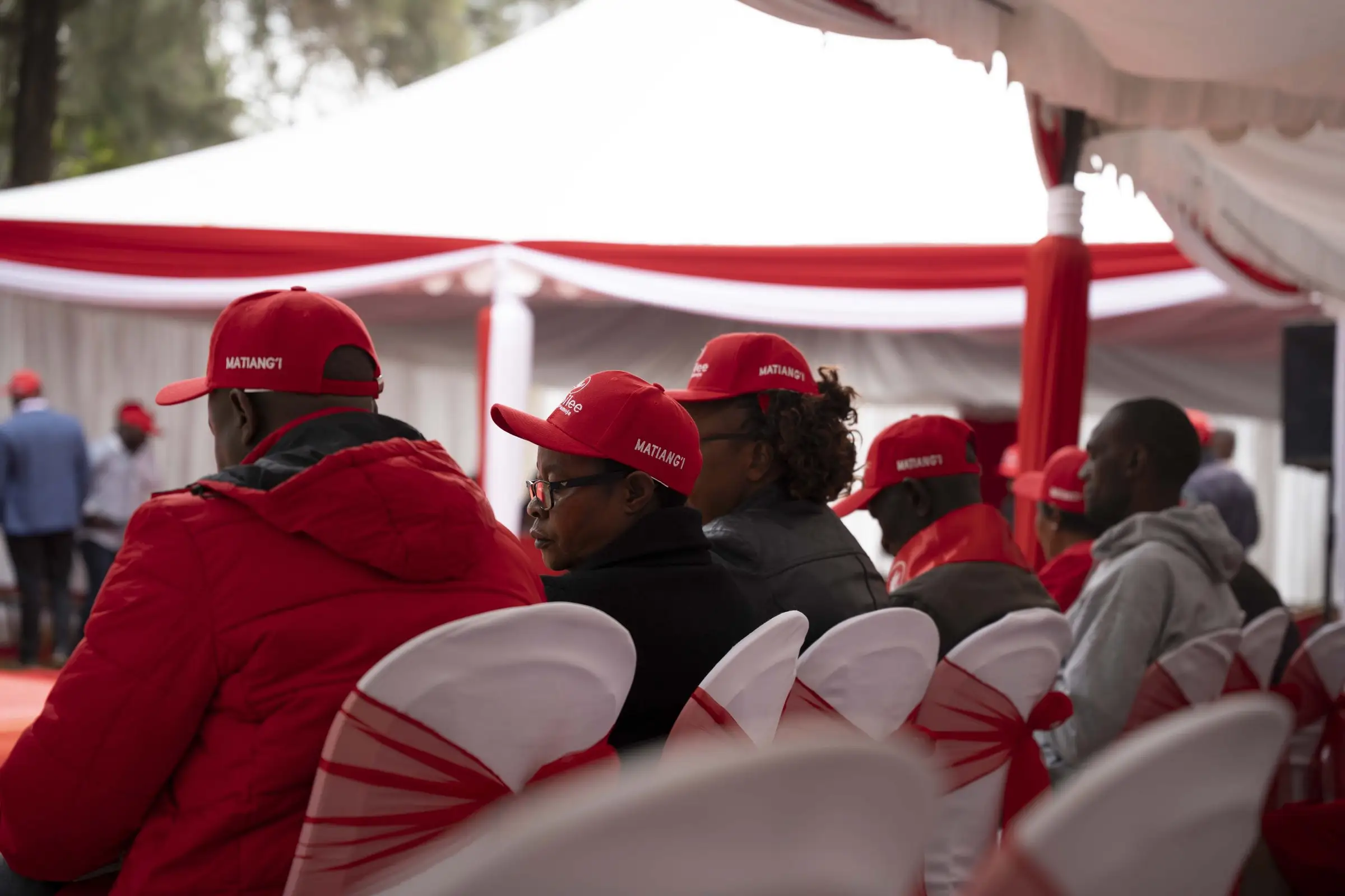 Supporters wearing red caps printed with Matiang'i