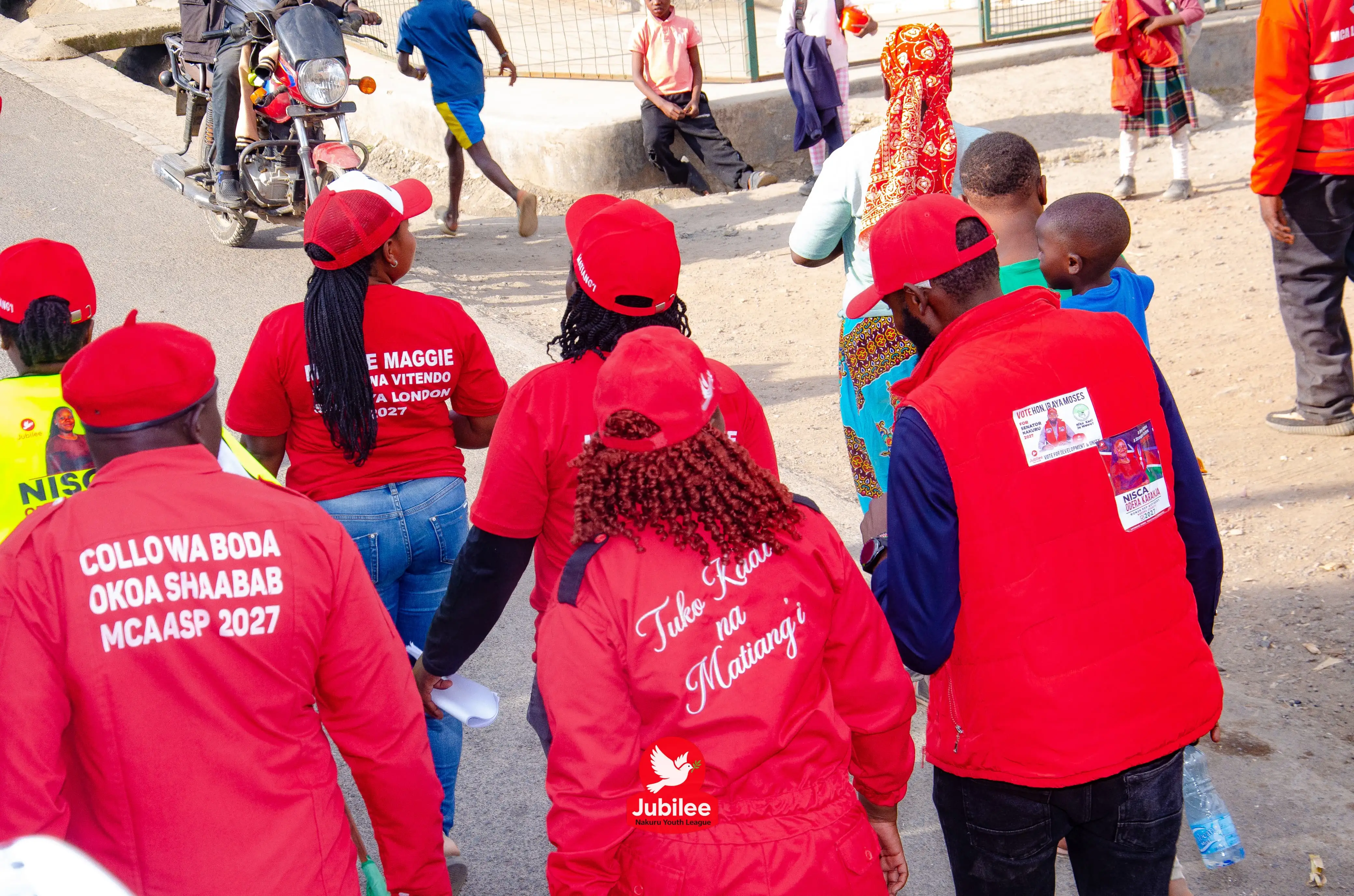 Supporters in red overalls with slogans printed on their backs