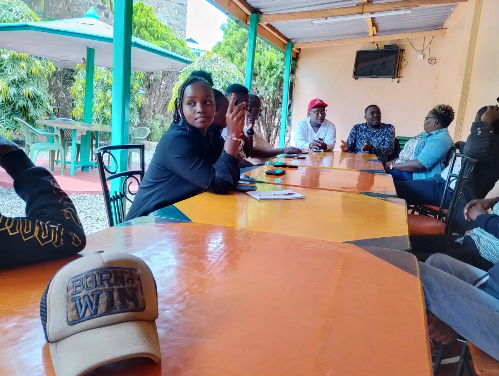 Strategy meeting around a table with a Born to Win cap in front